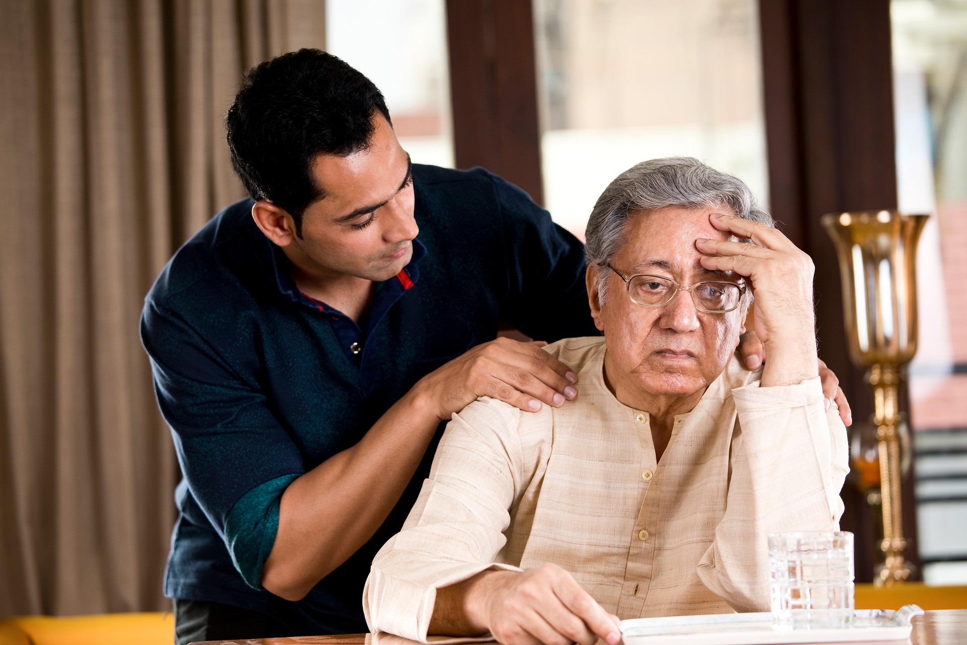 Son comforting father at home